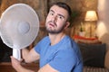 Man during unbearable heatwave using electric fan Royalty Free Stock Photo