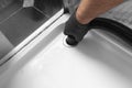 Man unblocking pipes in a bathroom shower cubicle using a hoover.