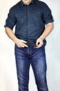 Man unbuttones blue jeans. Man torso, fingerring, blue shirt, casual wear. Royalty Free Stock Photo