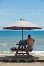 Man under a beach umbrella Royalty Free Stock Photo