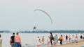 Man under the little canopy of a parachute taking off over the beach against cloudy sky Royalty Free Stock Photo