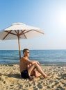 The man under a solar umbrella Royalty Free Stock Photo