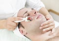 Man undergoes the procedure of medical micro needle therapy with a modern medical instrument derma roller. Royalty Free Stock Photo