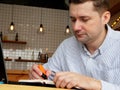 Man is underlined and working with laptop in cafe