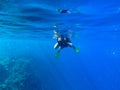 Man with underwater photocamera in blue sea water. Snorkeling in tropical seaside. Summer vacation in exotic island Royalty Free Stock Photo