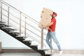 Man in uniform carrying carton boxes upstairs indoors Royalty Free Stock Photo