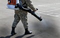 A man in uniform disinfects a city street