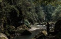 Man in uniform fishing near flowing river in woods