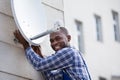 Man In Uniform Fitting TV Satellite Dish Royalty Free Stock Photo