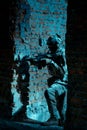 Man in uniform with machine gun and night-vision device move between two broken walls of building. Airsoft soldier in night Royalty Free Stock Photo