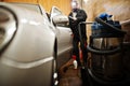 Man in uniform and respirator, worker of car wash center, cleaning car interior with hot steam cleaner. Car detailing concept Royalty Free Stock Photo