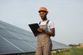 Man in uniform writing on clipboard at solar station Royalty Free Stock Photo