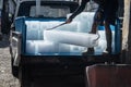 Man unloads ice blocks from a car with big iron hooks in fish marke