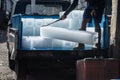 Man unloads ice blocks from a car with big iron hooks in fish marke