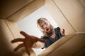 Man unpacking and opening carton box and looking inside Royalty Free Stock Photo