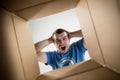 Man unpacking and opening carton box and looking inside Royalty Free Stock Photo