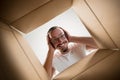 Man unpacking and opening carton box and looking inside Royalty Free Stock Photo