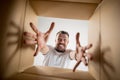 Man unpacking and opening carton box and looking inside Royalty Free Stock Photo