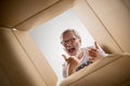 Man unpacking and opening carton box and looking inside Royalty Free Stock Photo