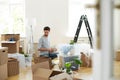 Man unpacking stuff from carton boxes after relocation to new home Royalty Free Stock Photo
