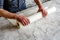 Man unraveling a rolled white wallpaper, illustrating home renovation and interior design in process