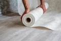 Man unraveling a rolled white wallpaper, illustrating home renovation and interior design in process