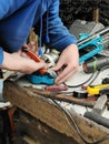 A man of unrecognizable appearance repairs an electrical appliance at home. Only his hands and tools are visible Royalty Free Stock Photo