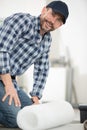 man unrolling roll floor insulation