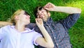 Man unshaven and girl lay on grass meadow. Couple in love united with nature. Nature fills them with freshness and