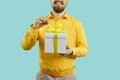 Man untying yellow ribbon on gift box with birthday present or holiday sale bonus