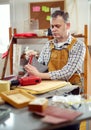 Man upholstering chair in his workshop, measure