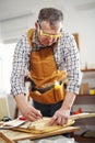 Man upholstering chair in his workshop, measure