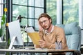 Man upset in office reading message on paper, businessman received mail envelope with notification and bad news, sitting Royalty Free Stock Photo