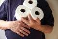 Man with upset stomach holds toilet paper