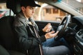 Man use disinfector in car. Handsome man protect himself and clean car inside using antiseptic