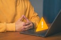Man use a laptop with caution warning sign for notification error. Cybersecurity technology concept of computer virus detect Royalty Free Stock Photo