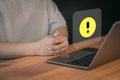 Man use a laptop computer with caution warning sign for notification error. Royalty Free Stock Photo