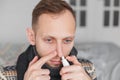 Man use nasal spray. concept of treatment for allergies or the common cold, winter style. Royalty Free Stock Photo