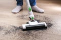 A man uses a bagless vertical cordless vacuum cleaner to clean floor Royalty Free Stock Photo