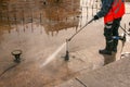 A man uses an electric pressure washer for a pressure washer. Cleaning city fountains in autumn. Workers remove the dirt that has Royalty Free Stock Photo