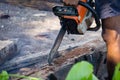 Man uses gasoline engine portable chainsaw cut timber into pieces