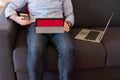 The man uses his mobile phone sitting on the sofa and in the meantime looks at the tablet and laptop Royalty Free Stock Photo