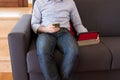 The man uses his mobile phone sitting on the sofa and in the meantime looks at the tablet Royalty Free Stock Photo