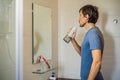 A man uses an oral irrigator in his bathroom