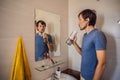 A man uses an oral irrigator in his bathroom