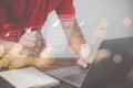 A man uses a pen to sign an electronic signature approved on an electronic document with a laptop working on an old wood table. Royalty Free Stock Photo