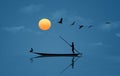 A man uses a pole to move a small boat and he is joined by a flock of pelicans