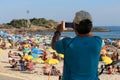 Man uses smartphone to photograph the beauty of Beach Royalty Free Stock Photo