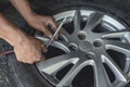 A man uses a stick type gauge to measure the air pressure of recently vulcanized tire