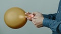 Man ties an inflated golden balloon, banner format